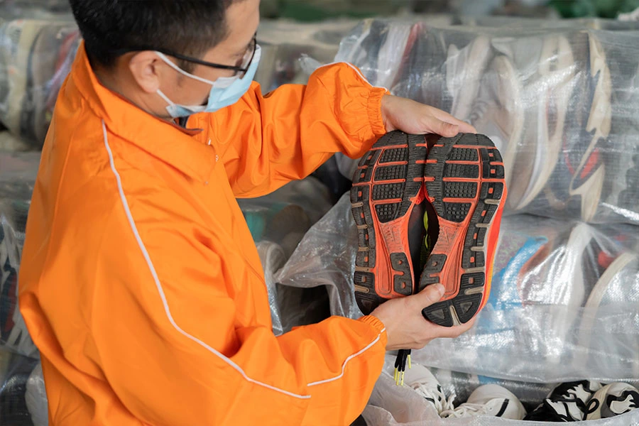 Sorter ensuring that the sole of a used vintage shoe pair meets our established standards.