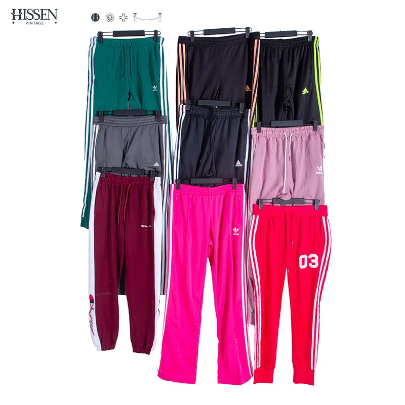 A collection of top-tier vintage used pants with bright colorful colors clipped on hangers.